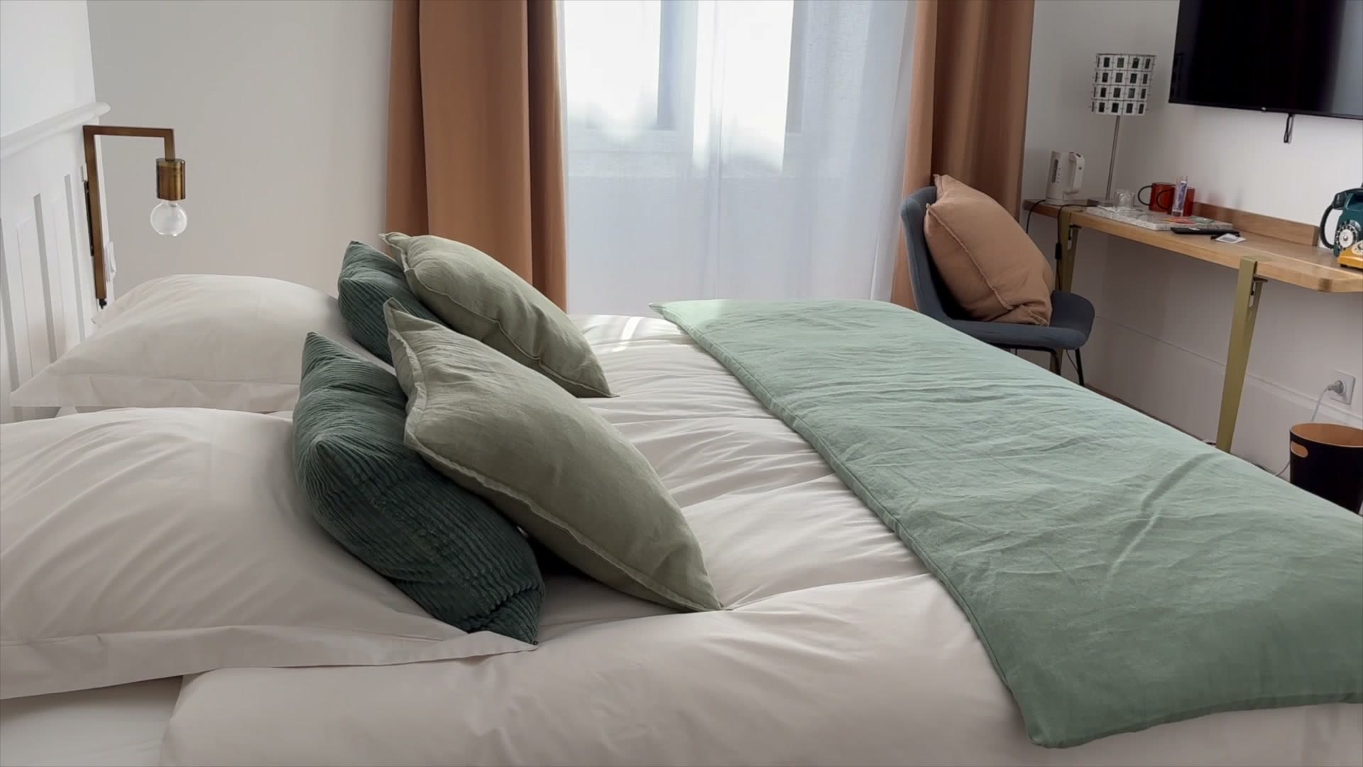 Chambre lumineuse de la Maison Bo Terra, lit fait avec linge vert et beige